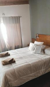 本塔纳山村Departamentos Ventana的一张配有白色床单和枕头的大床