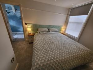 马盖特Sunset Point Apts - Blue Horizon Suite的一间卧室设有一张大床和两个窗户。