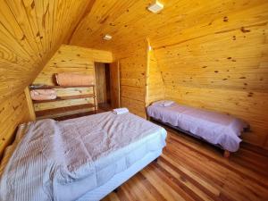 Bella UniónCabañas Jardines的小木屋内一间卧室,配有两张床