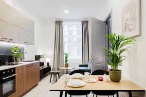 里加RIGAAPARTMENT ELIZABETES 22 Self-Service Aparthotel的厨房以及带桌椅的起居室。