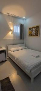 胡志明市VY庆旅馆 的白色的卧室设有床和窗户