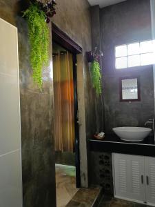 ต้นโพธิ์โฮมสเตย์的浴室配有盥洗盆、镜子和盥洗盆