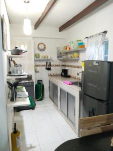 圣安德烈斯Mayo´s Place的厨房配有不锈钢冰箱和白色瓷砖地板。