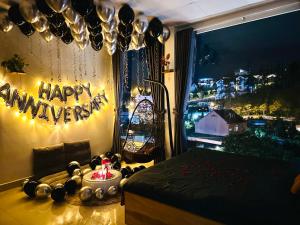 大叻Cloud River Homestay的卧室,窗户上有一个快乐的周年纪念标志