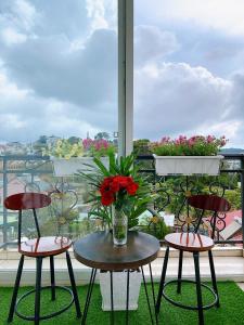 大叻Cloud River Homestay的阳台配有两把椅子和一张花瓶桌子。