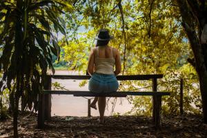 马尔多纳多港K'erenda Homet Reserva Natural的坐在长凳上的戴帽子的女人