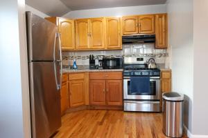 布鲁克林BGI Rentals的厨房配有木制橱柜和不锈钢冰箱。