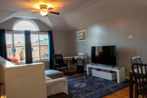 布鲁克林BGI Rentals的带沙发、电视和窗户的客厅