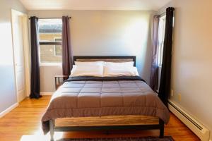布鲁克林BGI Rentals的一间卧室设有一张大床和大窗户