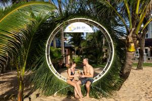 富国海之星度假酒店的坐在海滩上圆形镜子中的男女