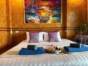 高兰深海海景民宿的一间卧室配有一张带蓝色枕头的床和一幅画
