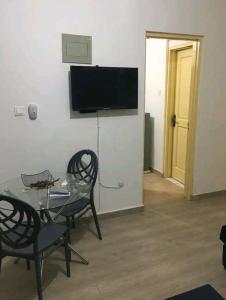 HanyaAjay's residence的客厅配有桌椅和电视。