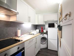 勒蒙多尔Appartement Mont-Dore, 2 pièces, 6 personnes - FR-1-415-149的厨房配有白色橱柜、洗衣机和烘干机