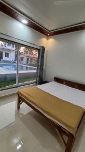 阿里巴格Mohor Retreat的一间卧室设有一张床和一个大窗户