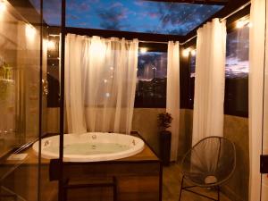 波苏斯-迪卡尔达斯Uai House com jacuzzi (Espaço romântico)的带浴缸的浴室和窗户。