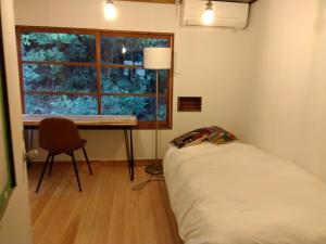 唐津朝食付き唐津里山の宿&ヨガ兎と亀的一间卧室配有一张床、一张书桌和一个窗户。