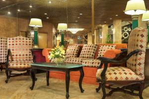 亚历山大蒙塔扎喜来登酒店的一间设有椅子和鲜花桌子的等候室