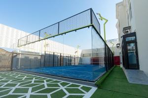 多哈La Maison Resort的一座位于大楼玻璃围墙内的网球场