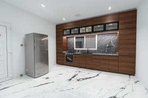 多哈La Maison Resort的厨房配有水槽和冰箱