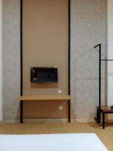 泗水Hotel Andita Syariah的一间墙上配有电视的房间