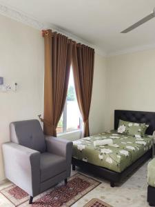 加央Heal Inn Roomstay - Islam Guest的卧室配有床、椅子和窗户。