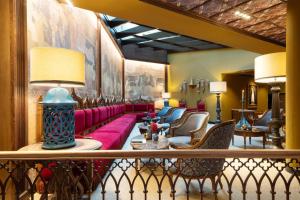 格拉纳达圣保拉宫傲途格精选酒店的大堂设有红色的沙发和椅子