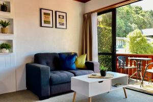 派西亚The Swiss Chalet Holiday Apartment 4, Bay of Islands的客厅配有蓝色的沙发和桌子