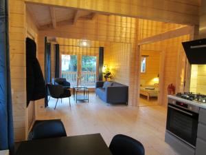 福尔特赫伊曾HderH - Eco Lodge op vakantiepark De IJsvogel, zwembaden, kids fun, natuur en rust的厨房以及带沙发和桌子的客厅。