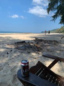 昌岛Changthong Bungalow的沙滩上长凳上的一罐苏打水