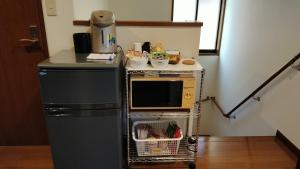 京都京都古都音旅馆的一间带微波炉和冰箱的小厨房