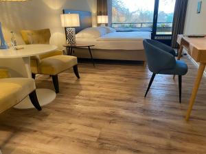 吕特延堡达斯奥斯特斯布里克酒店的卧室配有一张床和一张桌子及椅子