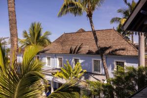 圣吉尔莱班布康格努酒店的一座棕榈树掩映的白色房子