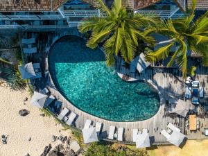 圣吉尔莱班布康格努酒店的享有带椅子和棕榈树的游泳池的顶部景致
