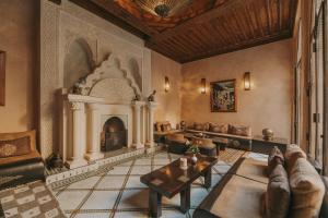 马拉喀什佩洛特布鲁套房及Spa摩洛哥传统庭院住宅的客厅设有壁炉和桌子