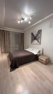 卡拉甘达Luxe Appartments on Stepnoy的一间卧室配有一张床,铺有木地板