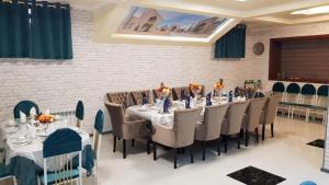 撒马尔罕Boutique Kamila Hotel的用餐室设有长桌子、椅子和墙壁