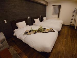 金泽VACATION RENT Kanazawa - Vacation STAY 63128v的两张位于酒店客房的床,上面有鲜花