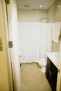 奥斯洛布AJ's Place Beach Resort的浴室配有白色的浴帘和卫生间