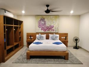 拉威海滩Beautiful private 3 bedroom villa with pool and gym的一间卧室配有一张床和吊扇