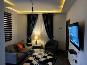 SunyaniKarjel Homes Apartments的带沙发和电视的客厅