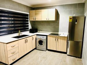 SunyaniKarjel Homes Apartments的厨房配有冰箱和洗衣机。