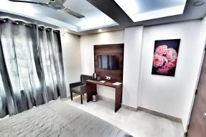 新德里Airport Hotel Delhi Aerocity的一间房间,配有一张桌子和一把挂着鲜花的椅子