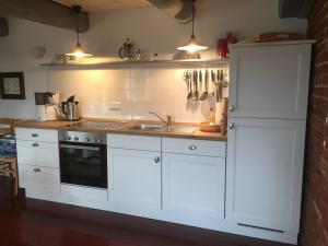 迪楚姆Hof Homfeld的厨房配有白色橱柜和水槽