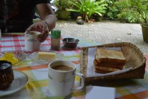 阿勒皮Bella Homestay Kerala的一张桌子,上面放着一篮面包和一杯咖啡