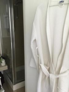 Sole StreetTHE HIDEAWAY - KENT的浴室的门上挂着白色的长袍