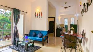 西奥利姆Poolside Paradise 1Bhk Luxury Apartment in Siolim.的客厅配有蓝色的沙发和桌子