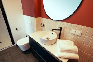 华沙B85 Suites的一间带水槽、卫生间和镜子的浴室