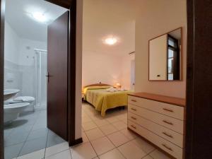 ChiusaforteAlbergo Martina的浴室设有一间卧室,配有一张床和一个水槽