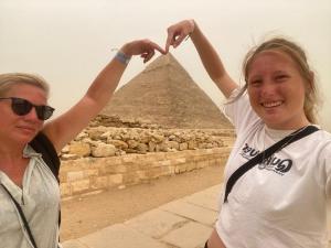 开罗LOVELY PYRAMIDS motel的站在金字塔前的妇女