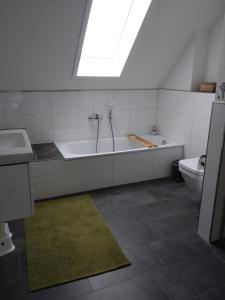 布特亚丁根Nordseehus-HYGGE的带浴缸、盥洗盆和卫生间的浴室